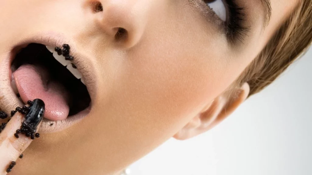 En  la foto, una mujer comiendo caviar